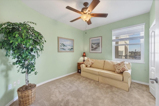 carpeted living area with a ceiling fan and baseboards