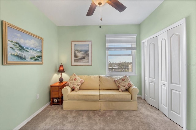 living area featuring baseboards, carpet floors, and a ceiling fan