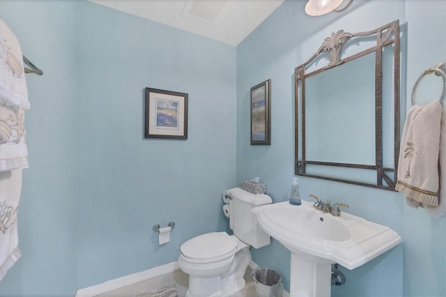 bathroom with baseboards and toilet