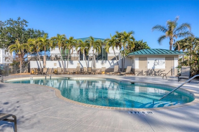 pool with a patio area and fence