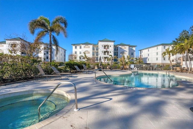 community pool featuring a patio area, a residential view, and a community hot tub