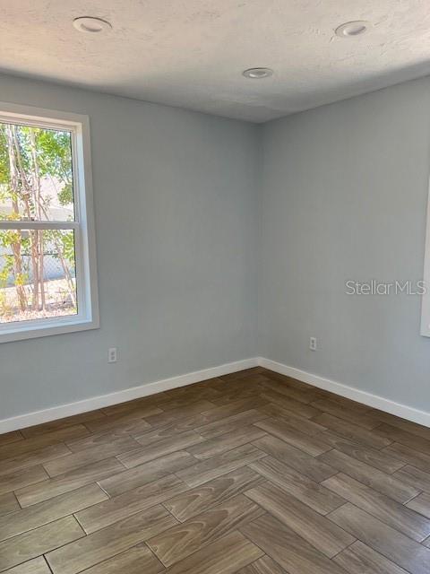 spare room with parquet floors and baseboards