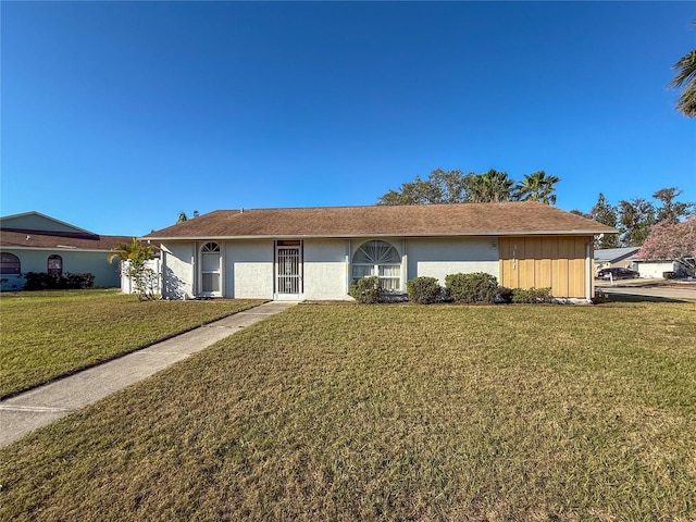 ranch-style house with stucco siding and a front yard