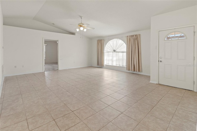 interior space featuring light tile patterned floors, baseboards, ceiling fan, and vaulted ceiling