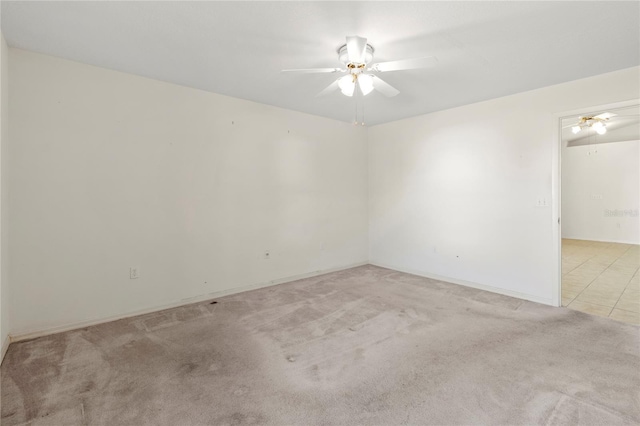 empty room featuring light colored carpet and a ceiling fan