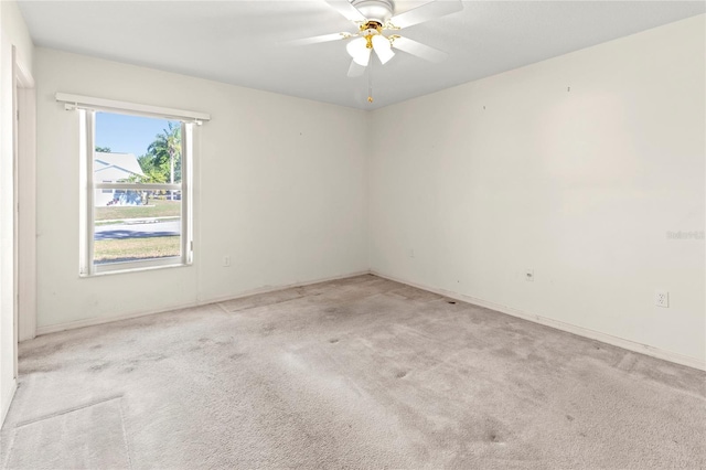 unfurnished room with light colored carpet and ceiling fan