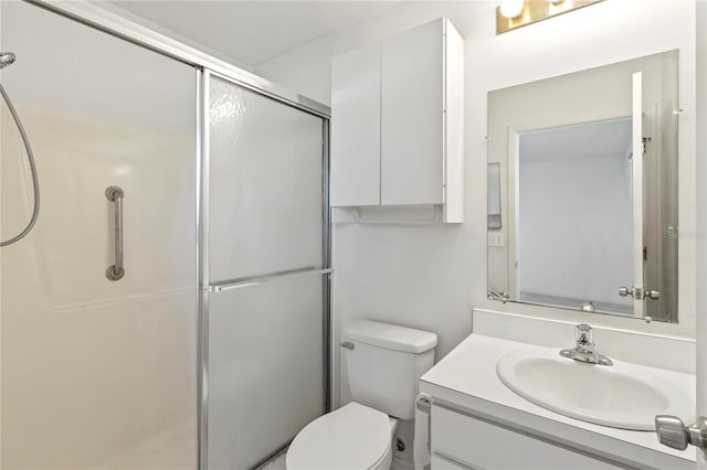 full bath with vanity, a shower stall, and toilet