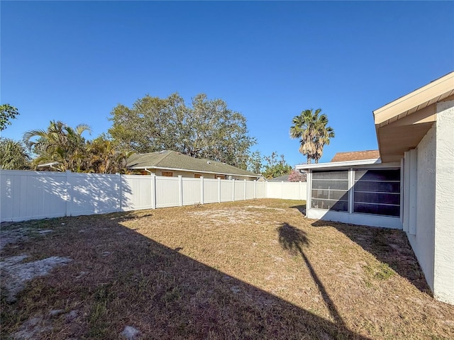 view of yard featuring a fenced backyard and a sunroom