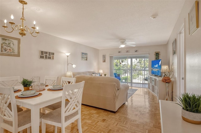 dining room featuring ceiling fan with notable chandelier and a textured ceiling