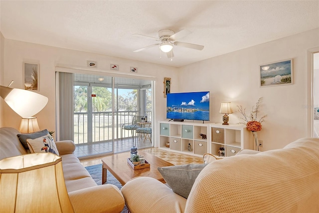 living area with a textured ceiling and a ceiling fan