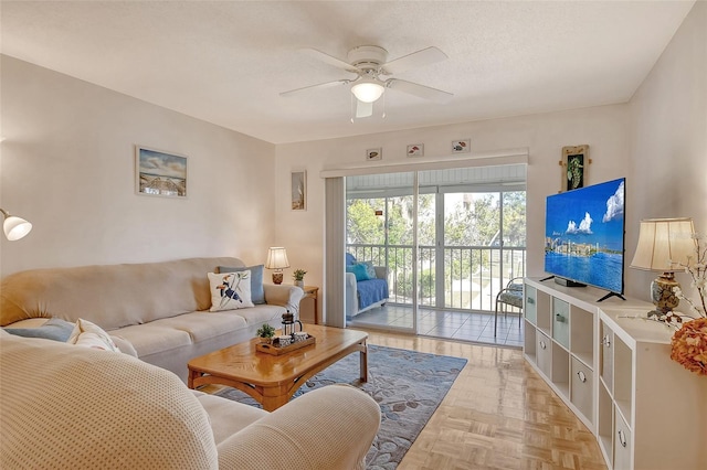 living area with a textured ceiling and ceiling fan