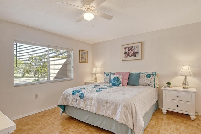 bedroom with ceiling fan, a textured ceiling, and baseboards