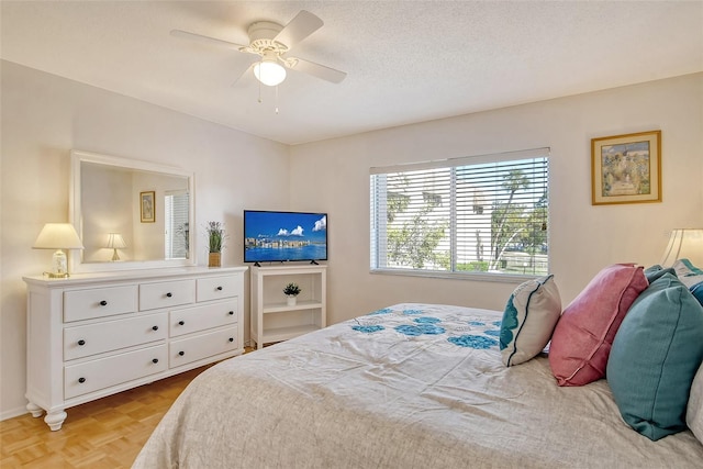 bedroom with a ceiling fan and a textured ceiling