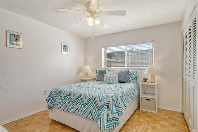 bedroom with a closet, baseboards, a textured ceiling, and a ceiling fan