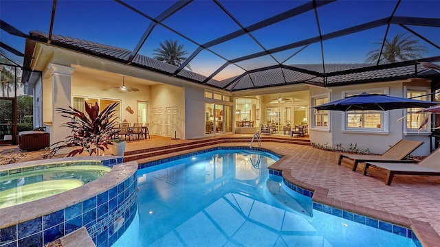 view of pool with a patio area, ceiling fan, glass enclosure, and a pool with connected hot tub