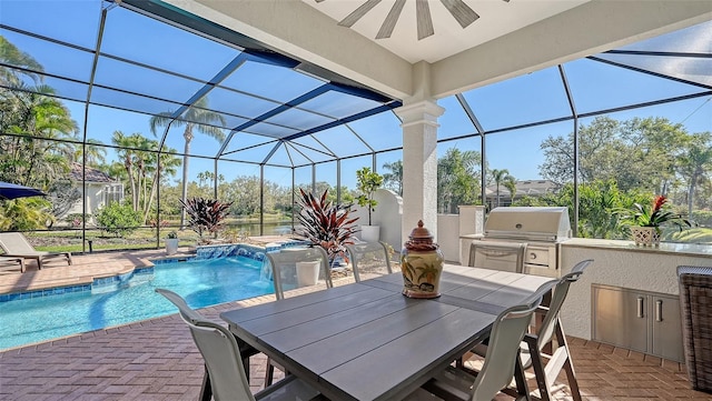 pool featuring a patio area, outdoor dining area, an outdoor kitchen, and glass enclosure