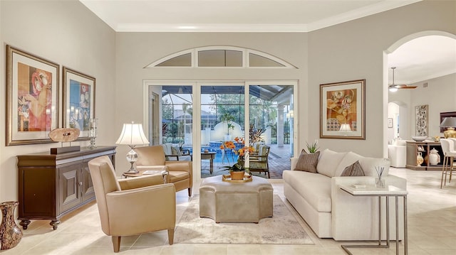 living area featuring crown molding, a ceiling fan, and arched walkways