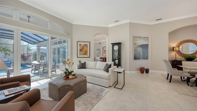 living area with baseboards, arched walkways, light tile patterned flooring, and crown molding