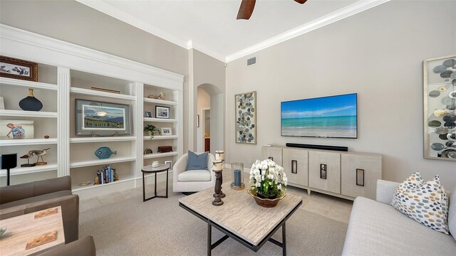 living area featuring arched walkways, visible vents, crown molding, and ceiling fan