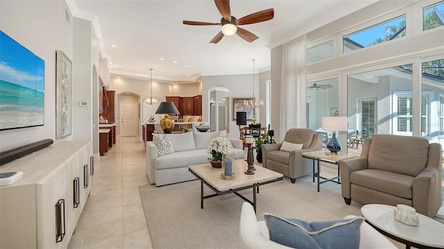 living area featuring ceiling fan with notable chandelier, recessed lighting, arched walkways, crown molding, and light tile patterned floors