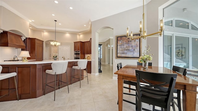 kitchen with light countertops, a notable chandelier, a peninsula, and arched walkways