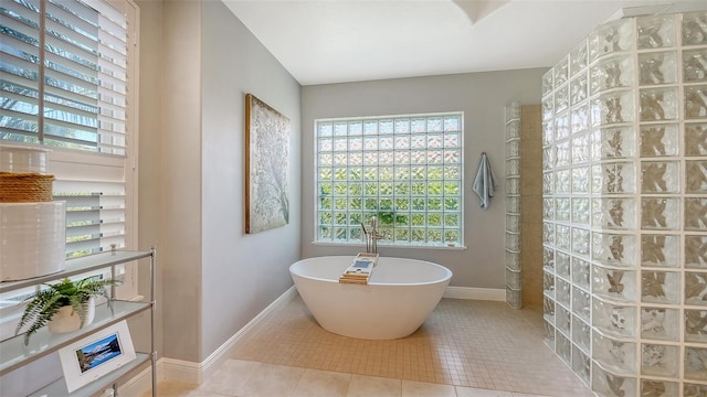 full bath with tile patterned flooring, a soaking tub, baseboards, and walk in shower