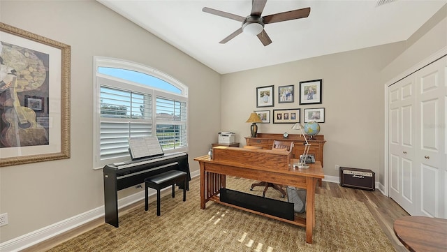 office with baseboards, wood finished floors, and a ceiling fan