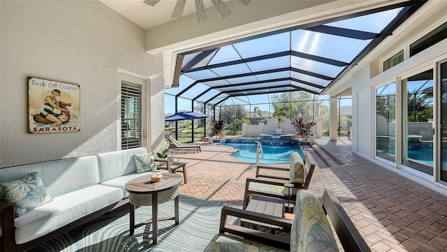 view of swimming pool featuring a patio, a pool with connected hot tub, ceiling fan, outdoor lounge area, and a lanai