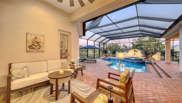 view of pool featuring glass enclosure, a patio, a ceiling fan, an outdoor living space, and a pool with connected hot tub