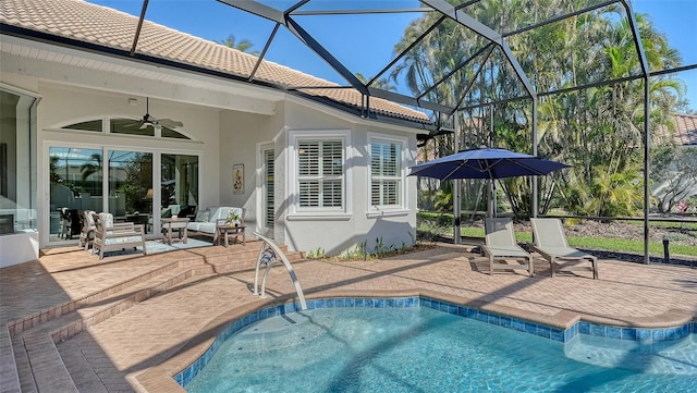 outdoor pool with glass enclosure, a patio, outdoor lounge area, and ceiling fan