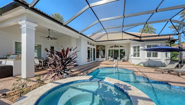 view of swimming pool with a ceiling fan, exterior kitchen, a patio area, and a pool with connected hot tub