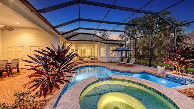 view of swimming pool with a pool with connected hot tub, a lanai, a ceiling fan, and a patio area