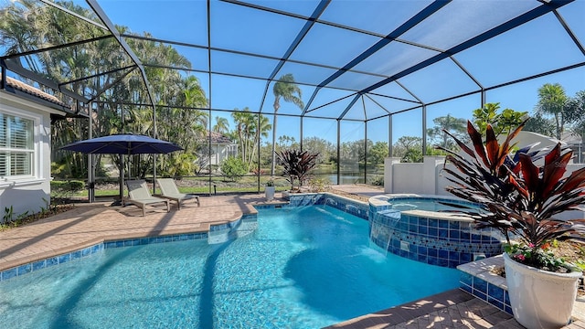 view of pool with a lanai, a pool with connected hot tub, and a patio