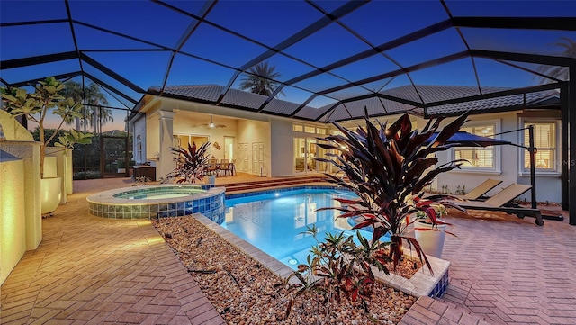 view of pool featuring a patio area, glass enclosure, a pool with connected hot tub, and a ceiling fan