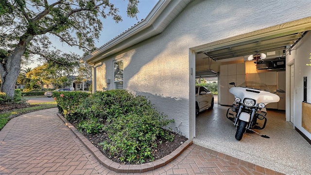 view of side of home featuring stucco siding and a garage