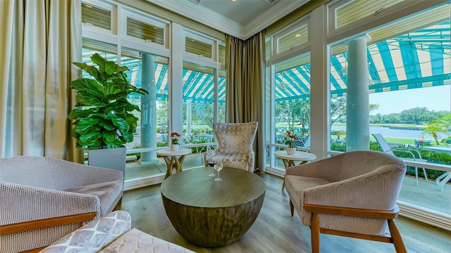 sunroom featuring a water view