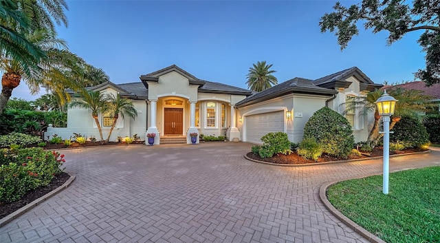 7340 Barclay Ct, University Park, FL 34201 - view of front of property with stucco siding, curved driveway, and a garage