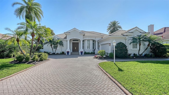 7340 Barclay Ct, University Park, FL 34201 - mediterranean / spanish-style home featuring decorative driveway, a garage, stucco siding, and a front lawn