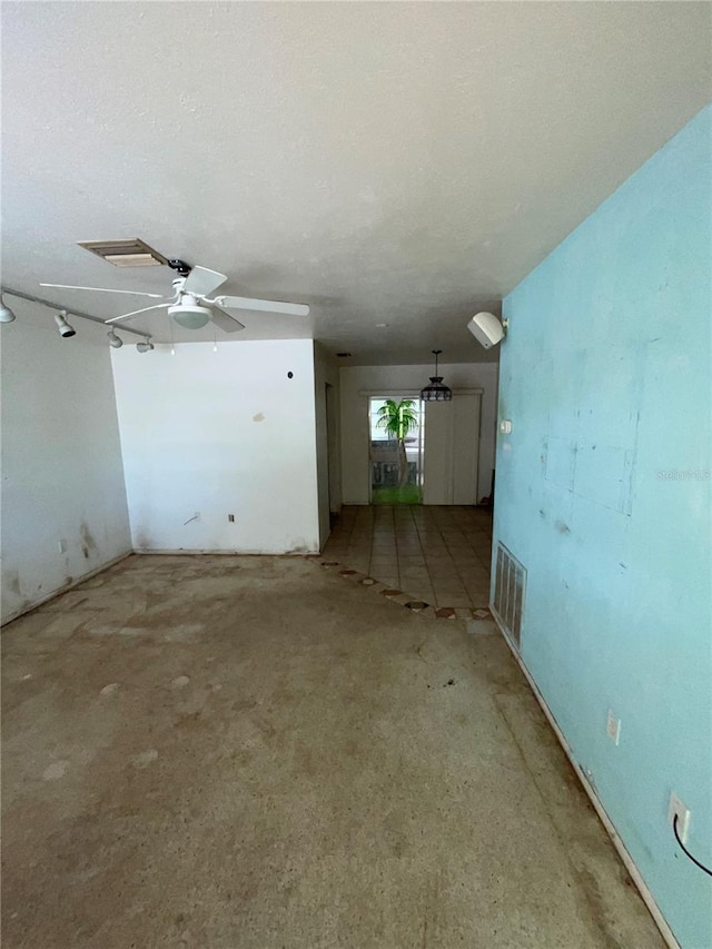 empty room with visible vents, a textured ceiling, and a ceiling fan