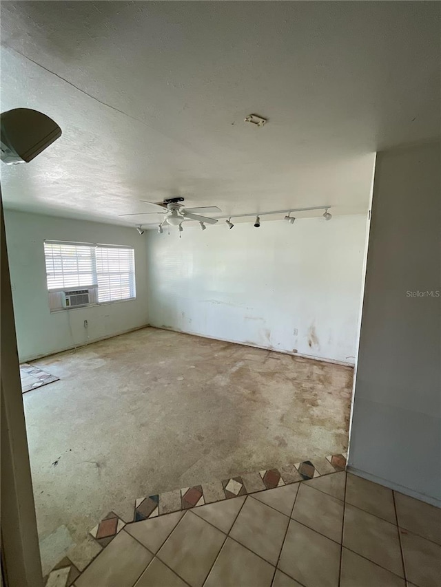 tiled spare room featuring a ceiling fan, a textured ceiling, cooling unit, carpet floors, and rail lighting