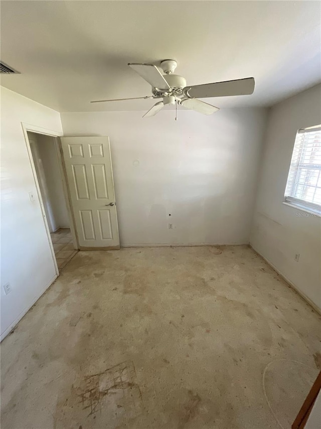 spare room featuring a ceiling fan and visible vents