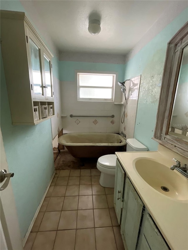 full bath with vanity, baseboards, tile patterned flooring, toilet, and a bathtub