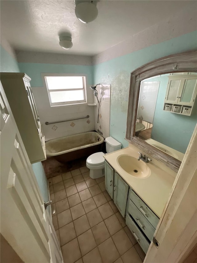 full bath featuring tile patterned floors, toilet, vanity, and a tub to relax in