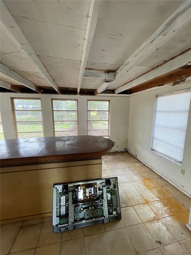 interior space featuring tile counters and beamed ceiling