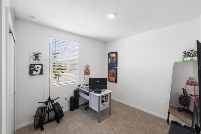 office space featuring light carpet, a textured ceiling, and baseboards