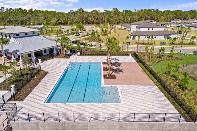 community pool with a patio area and fence