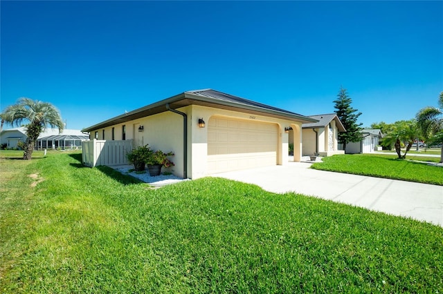 view of home's exterior with an attached garage, a lawn, driveway, and stucco siding