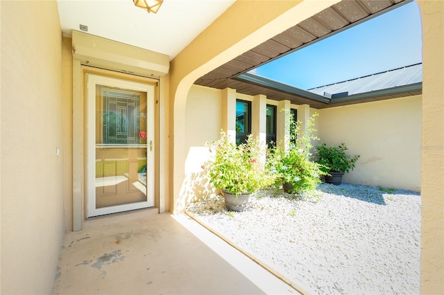 entrance to property featuring stucco siding