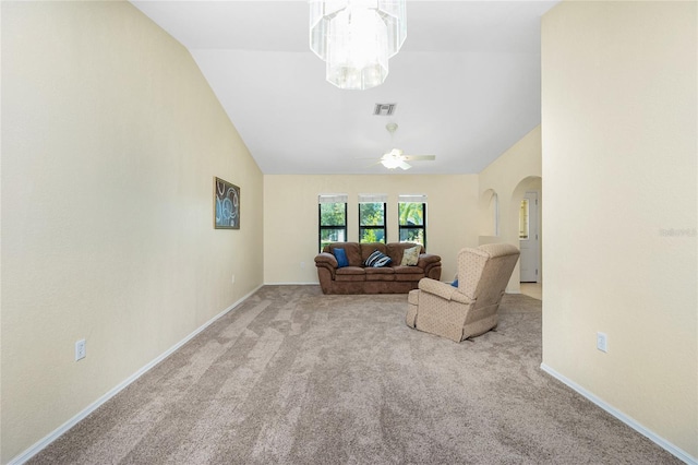 living area with visible vents, baseboards, lofted ceiling, carpet flooring, and ceiling fan with notable chandelier