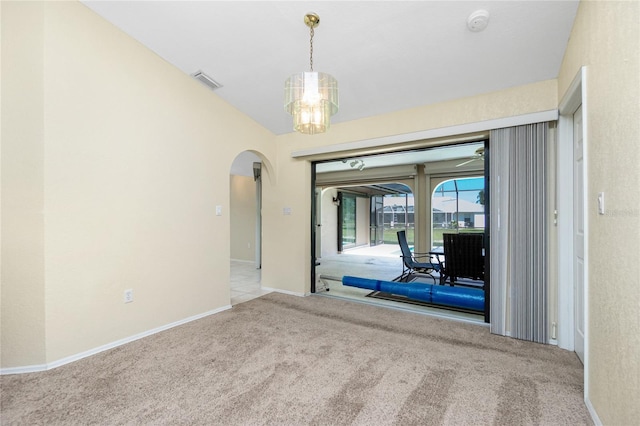 unfurnished room featuring carpet, baseboards, visible vents, arched walkways, and a chandelier